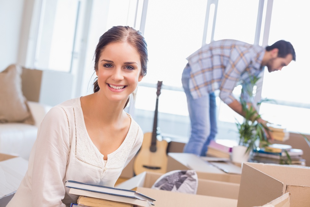 Cute couple packing up their library at home.