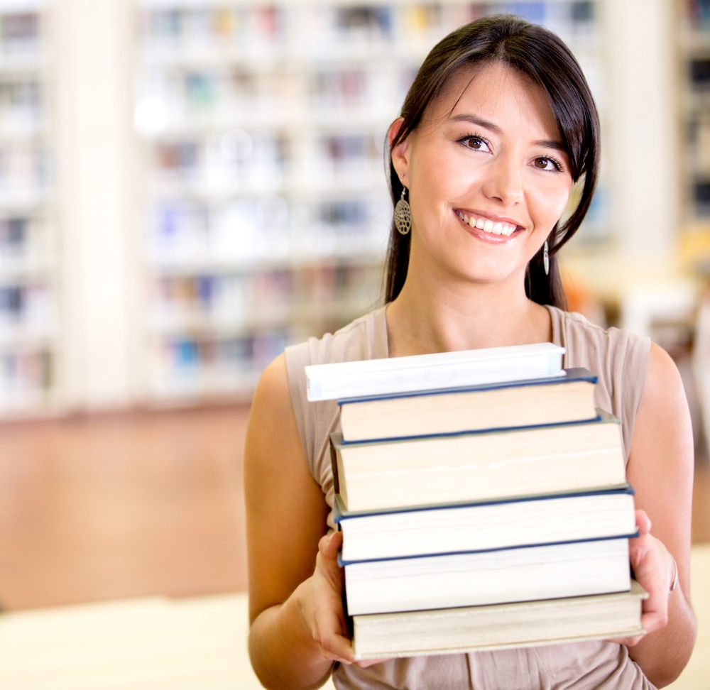 A woman packing up books that are not useful.