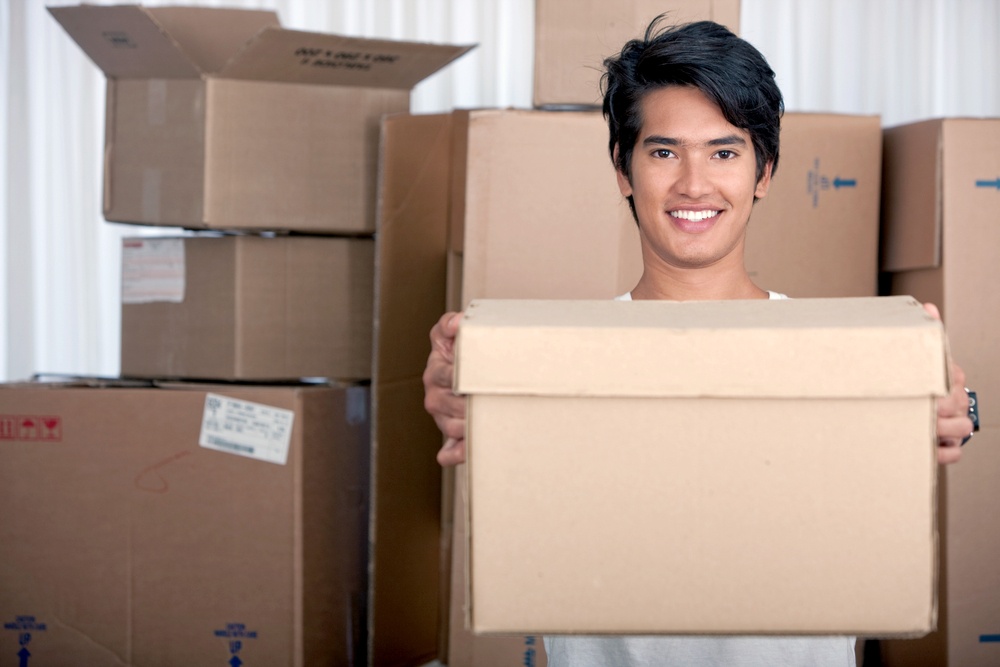 Man moving to a new home carrying boxes